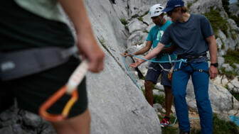 Bergführer demonstriert wie man eine Expresse einhängt