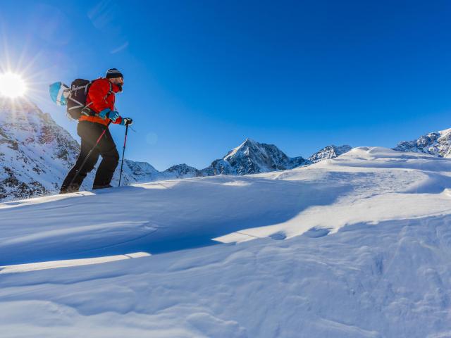 Schneeschuhwanderer bei Sonnenschein und Bergpanorama