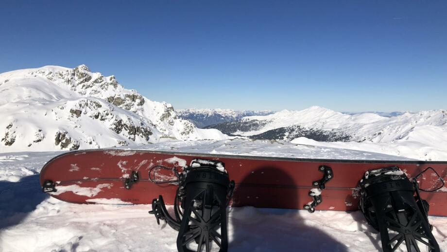 Ein Snowboard vor dem Gipfelpanorama im oberen Wattental auf dem Eiskarjoch.